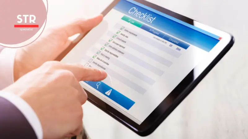 Airbnb Hosting A man is holding a tablet with the word "str" on it, while going through an Airbnb guest experience checklist.