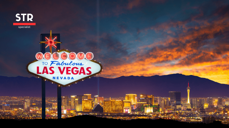 Airbnb Hosting Iconic Las Vegas welcome sign with city skyline at sunset captures the ultimate Vegas vibe.